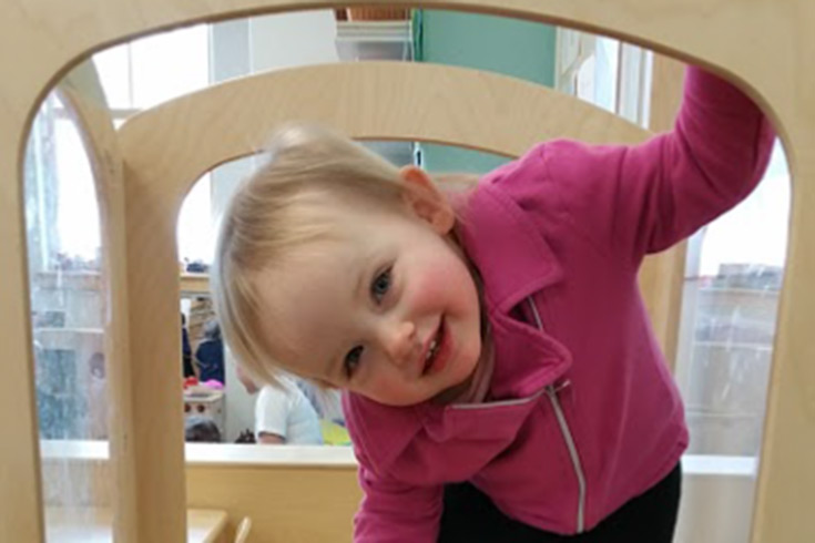 Infant smiling on a climbing structure