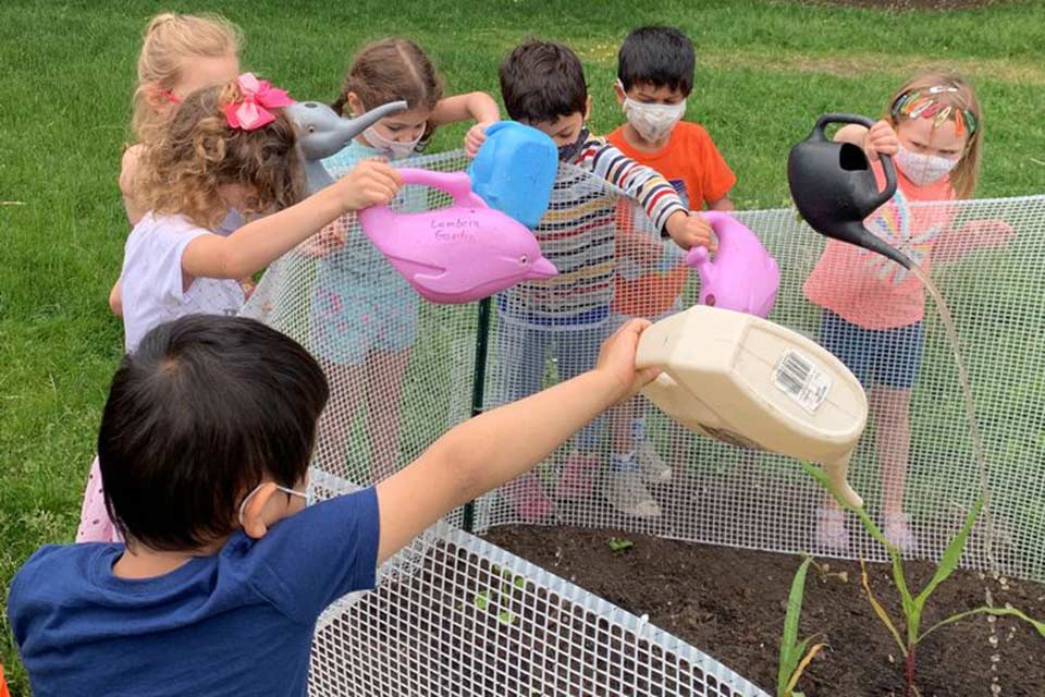 Children watering plants in the garden